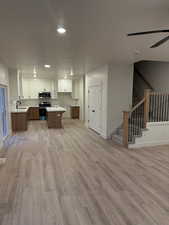 Kitchen featuring appliances with stainless steel finishes, sink, white cabinetry, and a center island