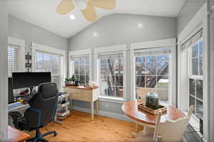 Office area with ceiling fan, lofted ceiling, and light wood-type flooring