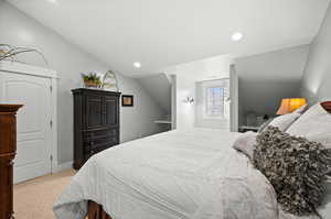 Carpeted bedroom with lofted ceiling