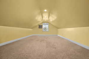 Bonus room with lofted ceiling and carpet flooring