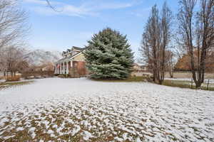 Yard layered in snow with a mountain view