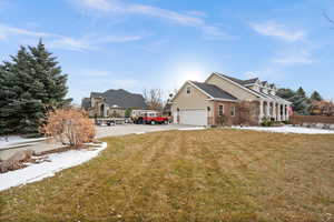 View of front of home with a front yard and a garage