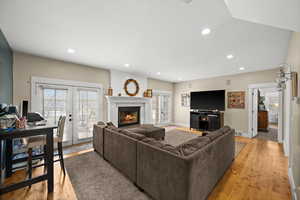 Living room with light hardwood / wood-style floors, a wealth of natural light, and french doors