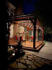 Patio at night with a pergola and a wooden deck