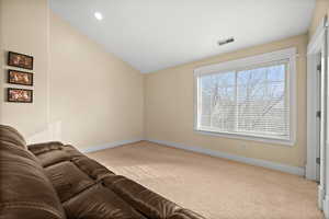 Living room with light colored carpet and vaulted ceiling