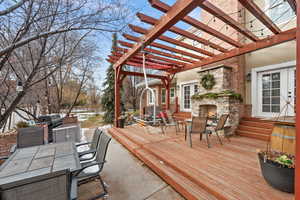 Deck featuring a pergola, a grill, and an outdoor stone fireplace