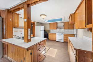 Kitchen with tile counters, decorative backsplash, and white appliances