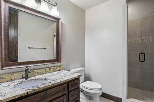 Bathroom with a shower with door, vanity, and toilet