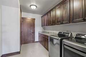 Laundry area featuring cabinets, separate washer and dryer, and light tile patterned floors