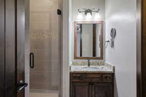 Bathroom featuring vanity and a shower with shower door