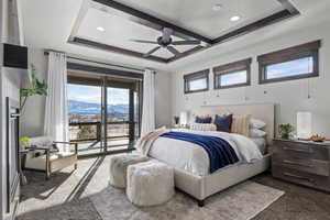 Carpeted bedroom with a mountain view, access to outside, a raised ceiling, and ceiling fan