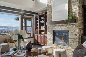 Living room with a stone fireplace, a mountain view, and hardwood / wood-style floors