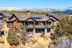 Rear view of house with a mountain view and a balcony