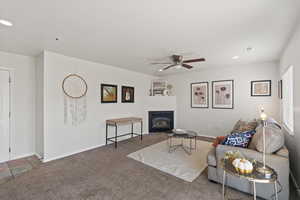 Living room featuring ceiling fan and carpet