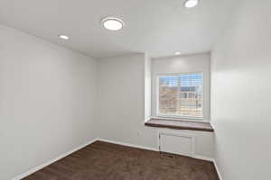 Unfurnished room featuring dark carpet