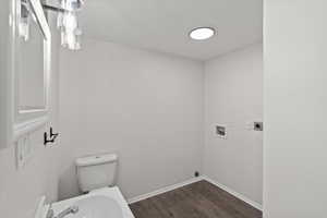 Bathroom with hardwood / wood-style flooring and toilet