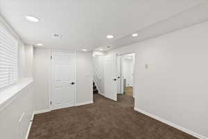 Basement with dark colored carpet