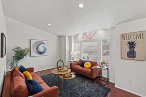 Living room featuring dark hardwood / wood-style flooring and lofted ceiling