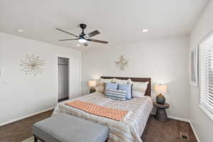 Carpeted bedroom featuring ceiling fan and a closet