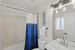 Full bathroom with toilet, vanity, and shower / bath combination with curtain