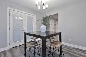 Dining space featuring an inviting chandelier and dark hardwood / wood-style flooring