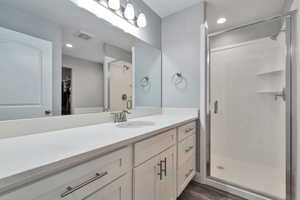 Bathroom featuring a shower with door, hardwood / wood-style floors, and vanity