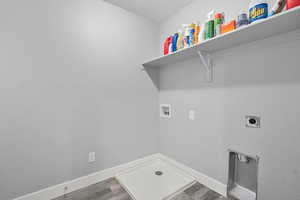 Washroom with dark wood-type flooring, washer hookup, hookup for an electric dryer, and a textured ceiling