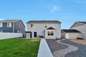 Rear view of property with a storage shed, a lawn, and a patio