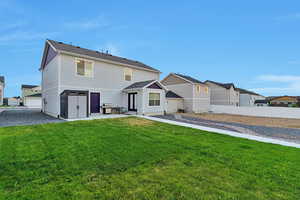 Back of property featuring a lawn and a patio