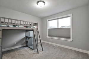 Unfurnished bedroom featuring a textured ceiling and carpet