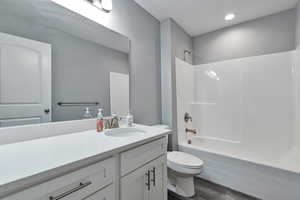 Full bathroom featuring bathtub / shower combination, hardwood / wood-style floors, toilet, and vanity