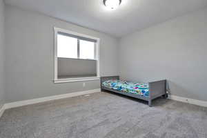 Bedroom featuring carpet and a textured ceiling