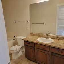 Bathroom featuring toilet, vanity, a bathtub, and tile patterned floors