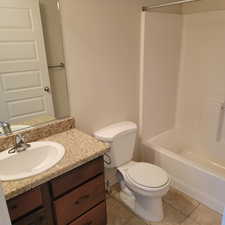 Full bathroom featuring shower / bathing tub combination, toilet, vanity, and tile patterned flooring