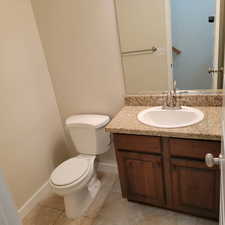 Bathroom with toilet, tile patterned flooring, and vanity