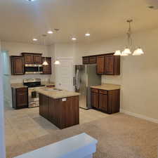 Kitchen with appliances with stainless steel finishes, sink, a chandelier, and pendant lighting