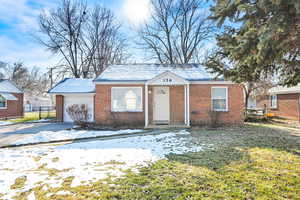 View of front of property with a garage and a yard