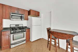 Kitchen featuring light tile patterned floors and stainless steel appliances