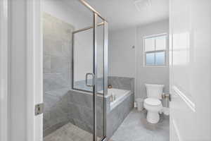 Bathroom featuring separate shower and tub and toilet