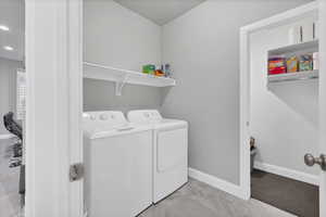 Clothes washing area with washer and clothes dryer - entrance to storage room.