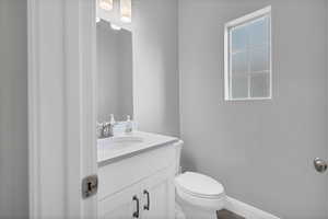 Bathroom featuring vanity, a wealth of natural light, and toilet