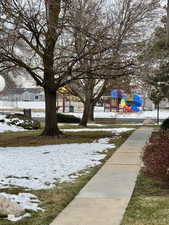 Snowy yard featuring a playground