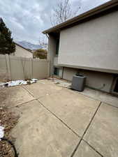 Fenced Patio, View of home's exterior with central air condition unit, a mountain view, and a patio