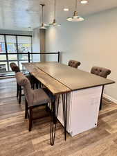 Dining area with a textured ceiling and hardwood / wood-style floors