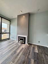 Unfurnished living room with a textured ceiling, hardwood / wood-style floors, and a fireplace