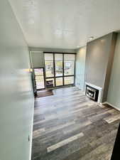 Unfurnished living room featuring a textured ceiling, a fireplace, and expansive windows