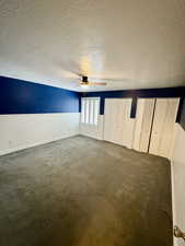 Master Bedroom room with ceiling fan, a textured ceiling, and dark colored carpet