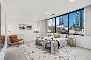 Carpeted bedroom featuring floor to ceiling windows