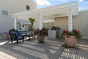 View of patio featuring an outdoor kitchen, area for grilling, and a pergola