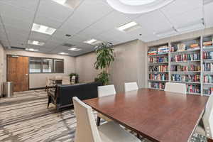 Dining room with carpet floors, a paneled ceiling, and built in features